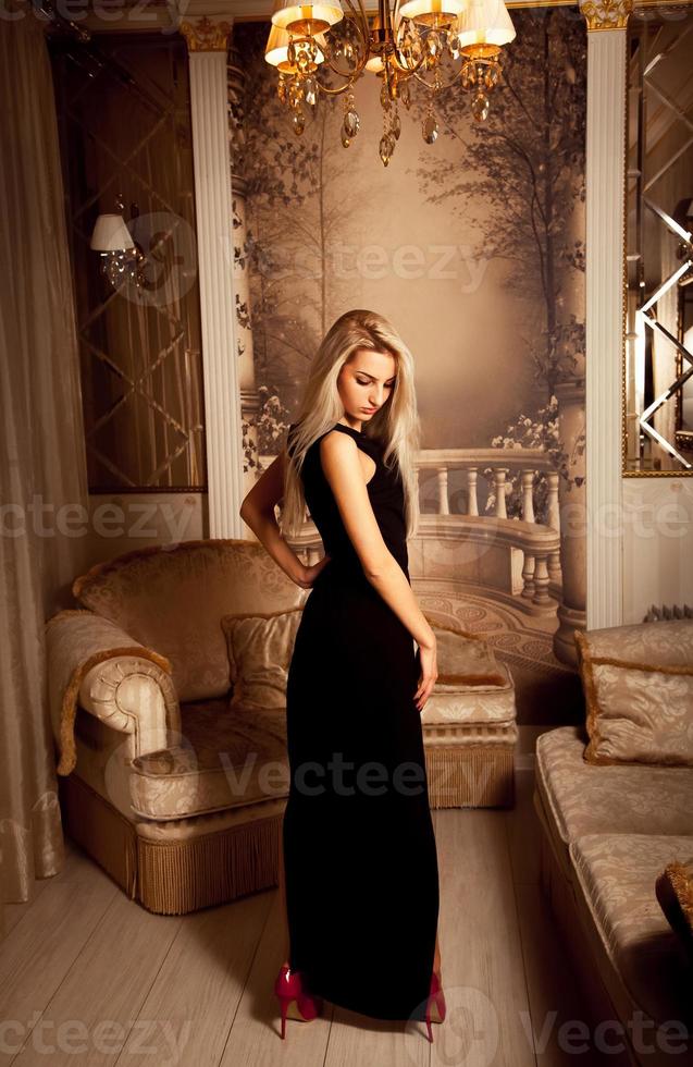 femme blonde sexuelle mince en longue robe noire et talons hauts rouges photo