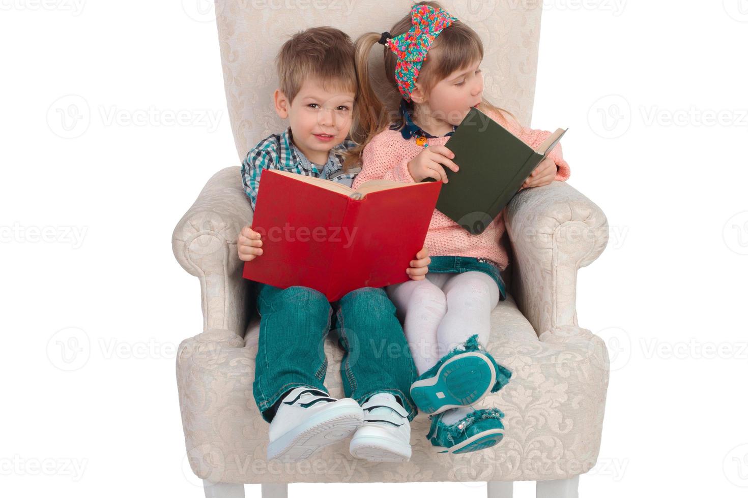 les enfants sont assis sur une chaise avec des livres photo