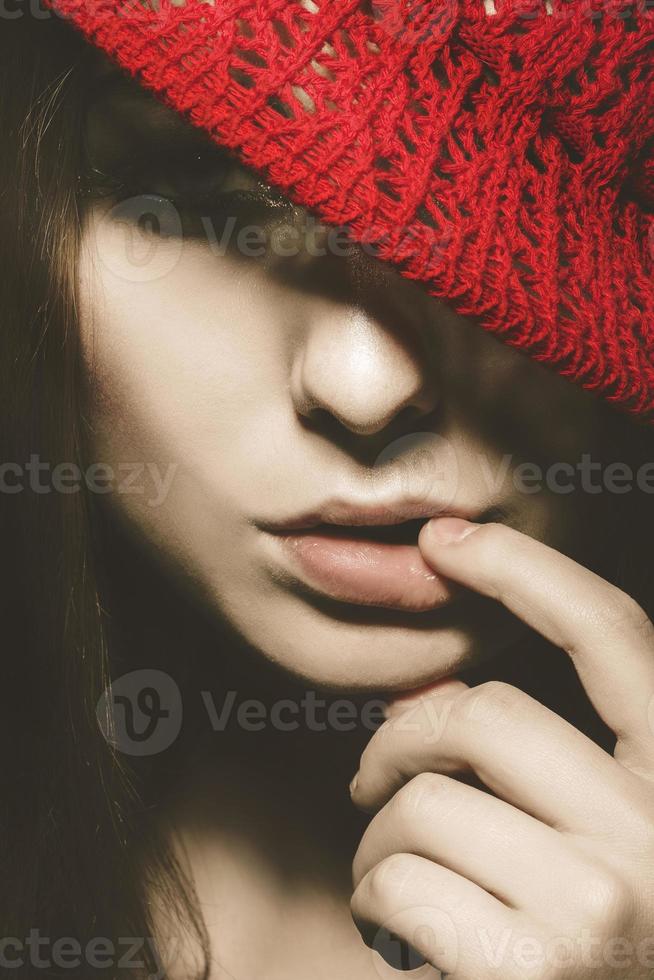 portrait vertical d'une jolie femme avec un chapeau rouge et un doigt près des lèvres dans un style rétro photo