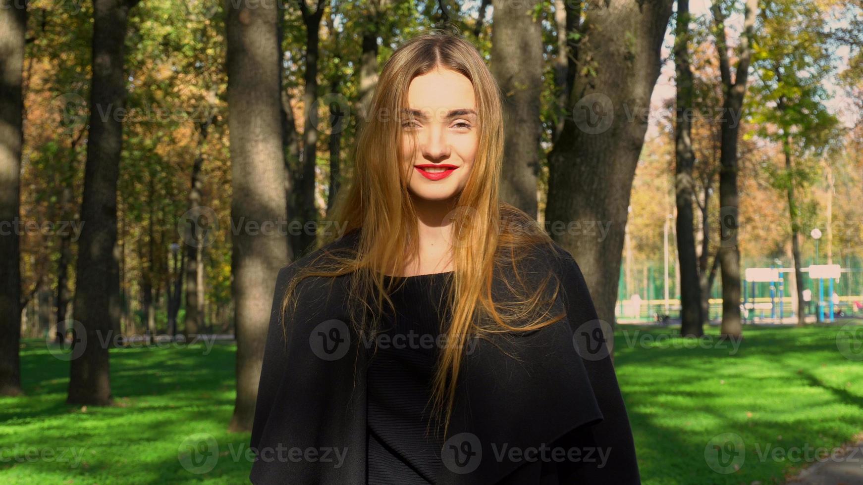 femme aux lèvres rouges en manteau élégant à l'extérieur photo