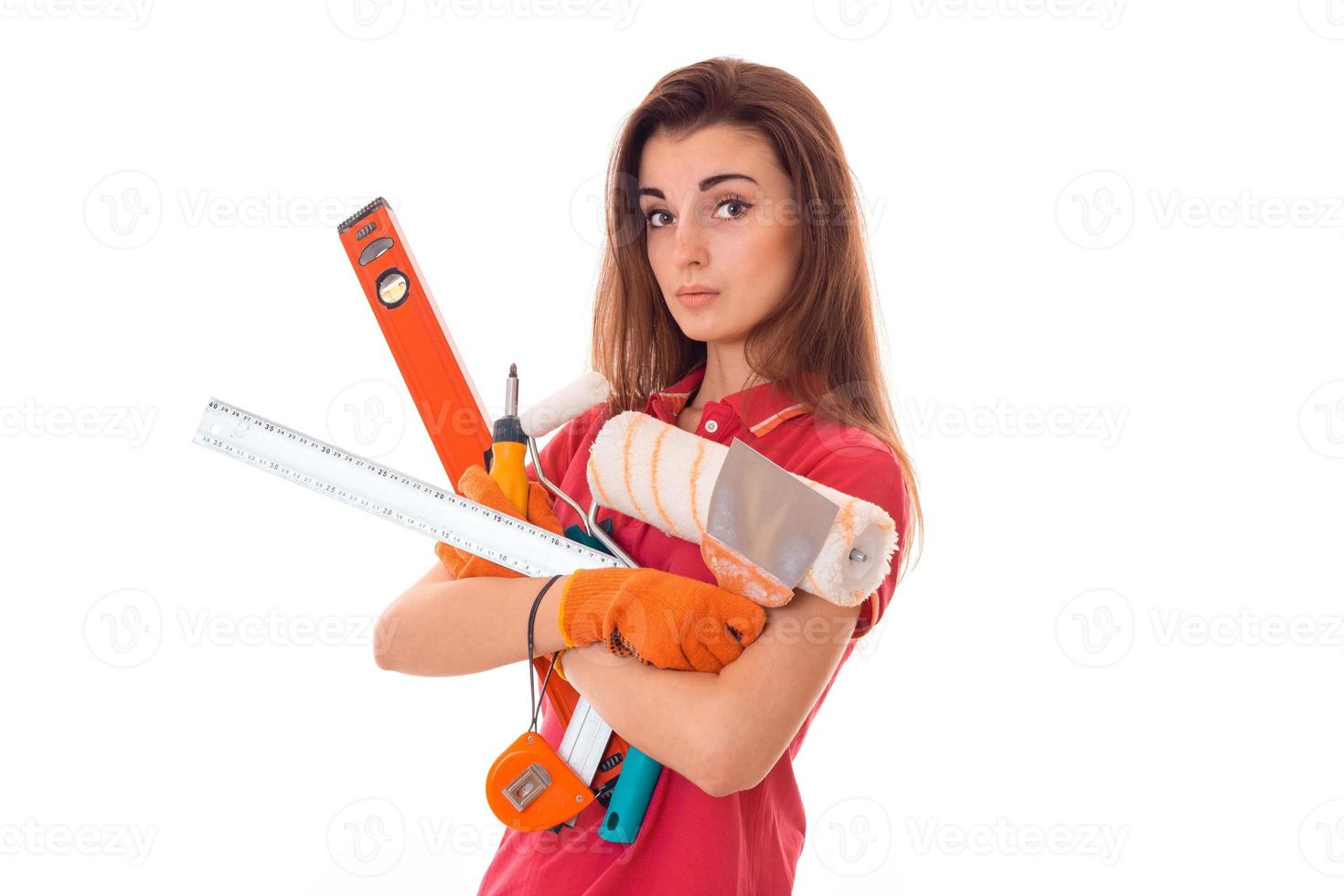 jeune charmante fille constructeur en uniforme avec beaucoup d'outils rend la rénovation isolée sur fond blanc photo