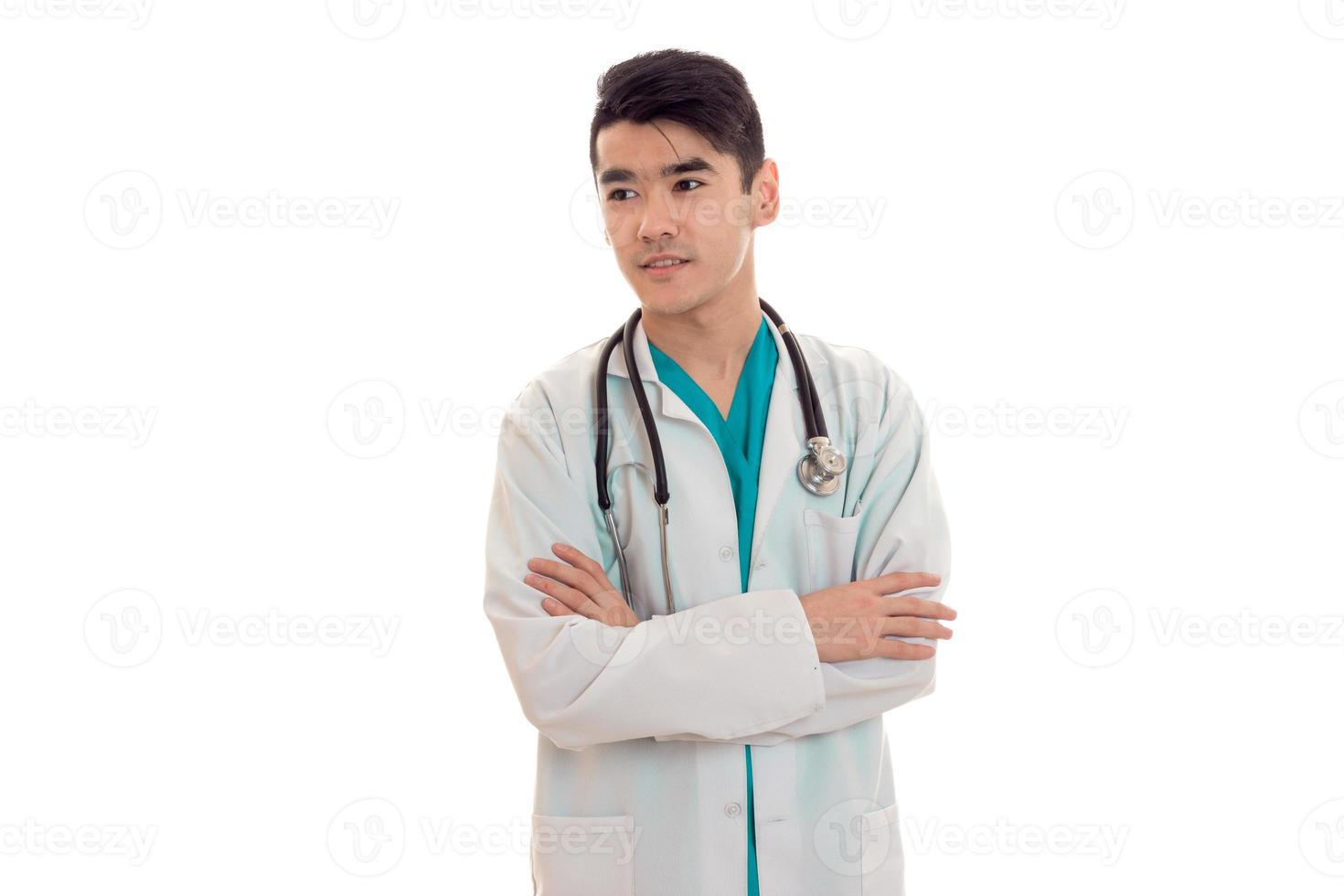 Portrait en studio d'un médecin de sexe masculin en uniforme posant et regardant loin isolé sur fond blanc photo