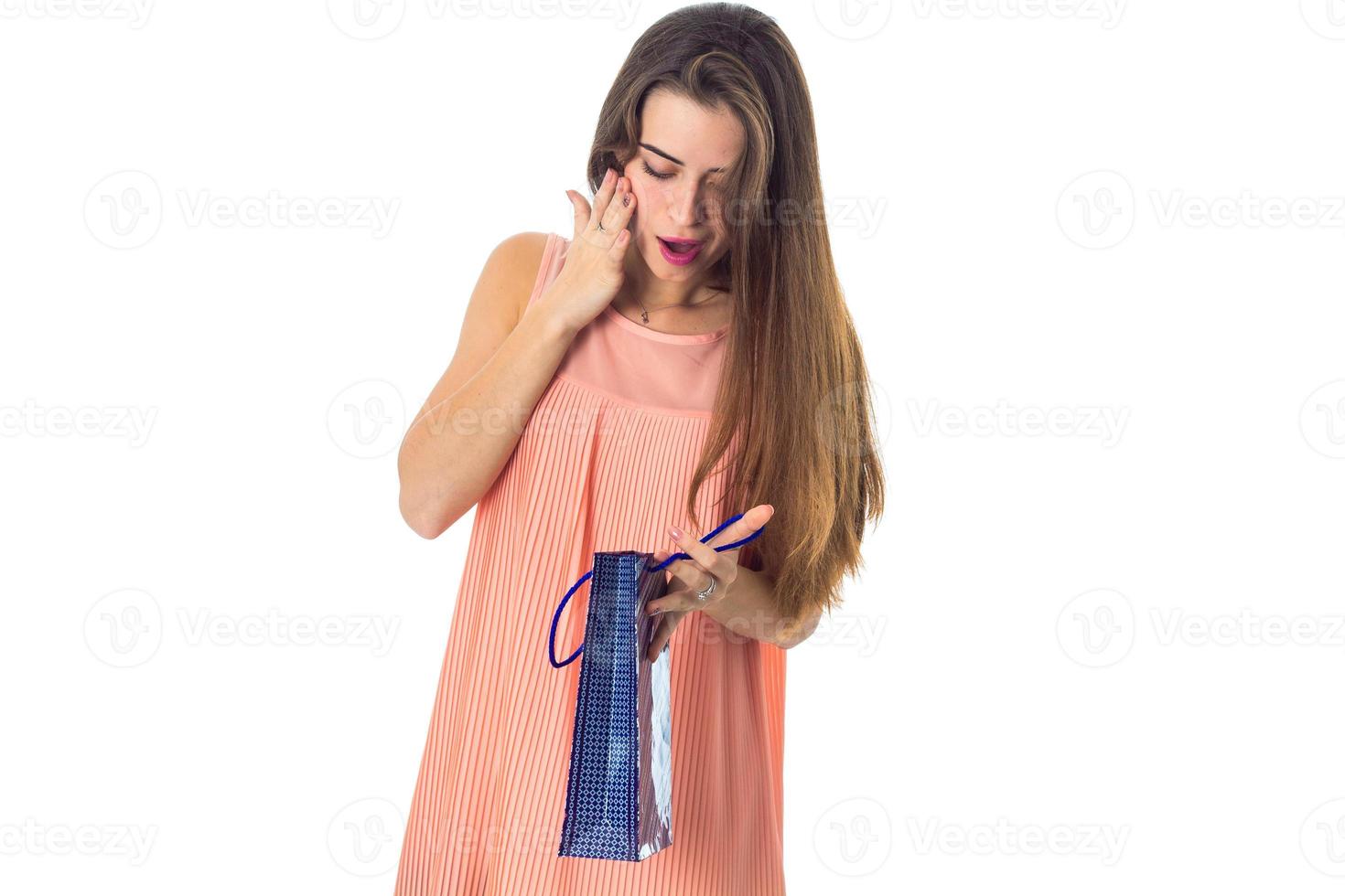 jeune fille cherche paquet avec cadeau isolé sur fond blanc photo