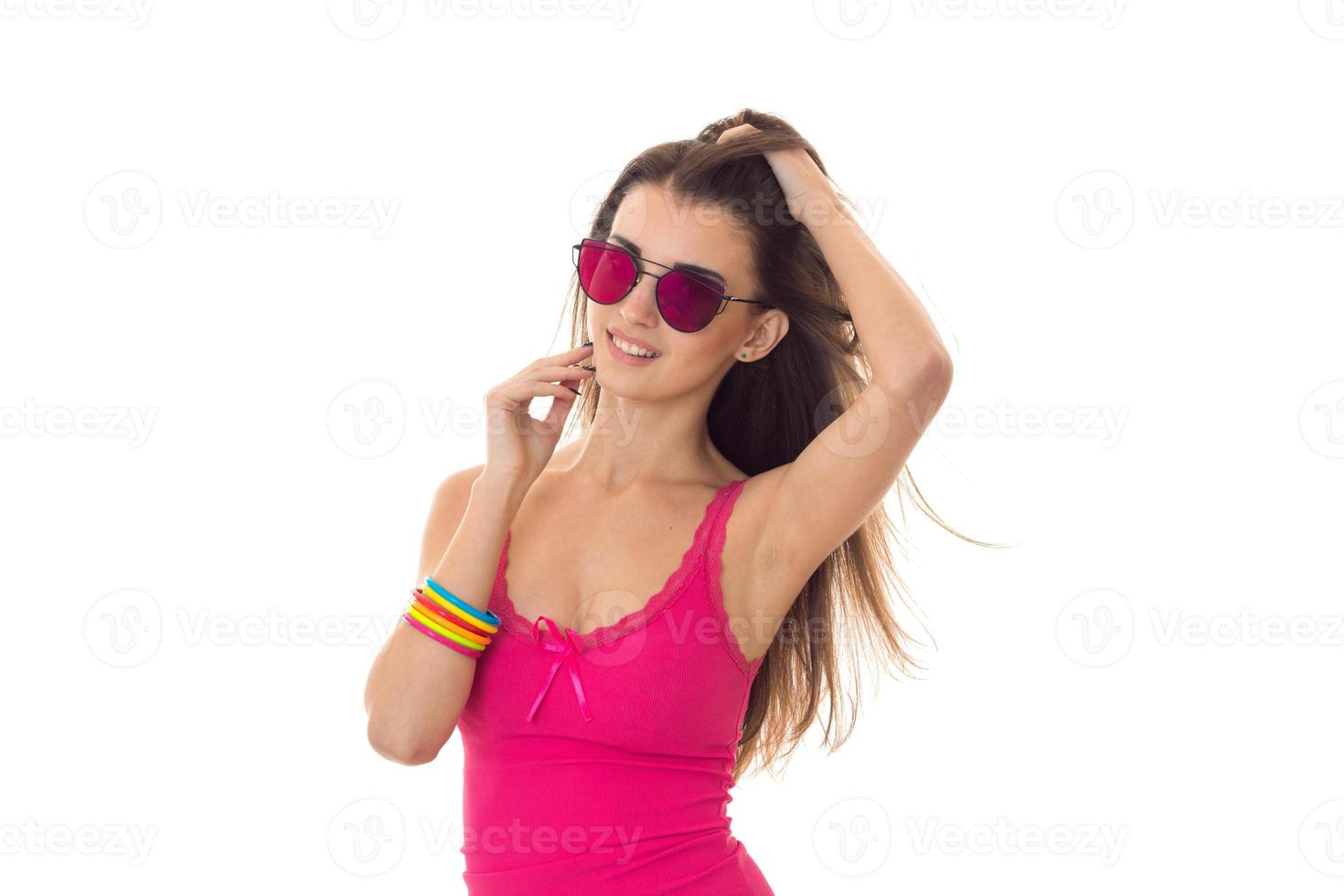 beauté jeune fille en chemise légère rose et lunettes de soleil posant et souriant isolé sur fond blanc photo