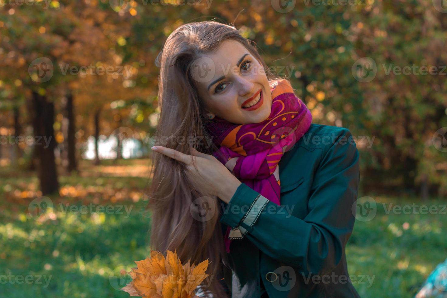 douce fille se tient dans la rue en souriant et redresse les cheveux photo