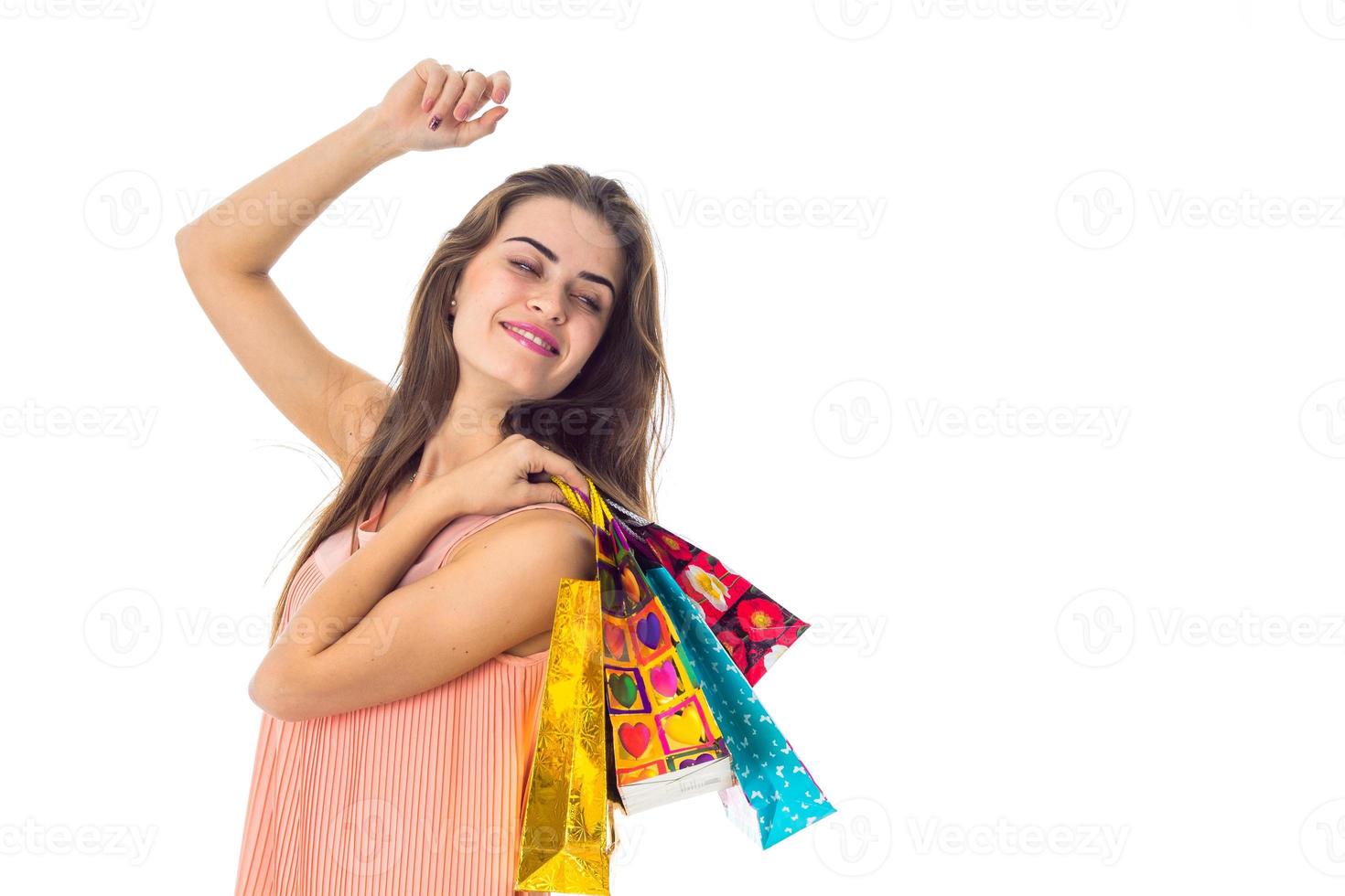 joyeuse jeune fille leva la main et l'autre détient beaucoup de paquets avec des cadeaux est isolé sur fond blanc photo