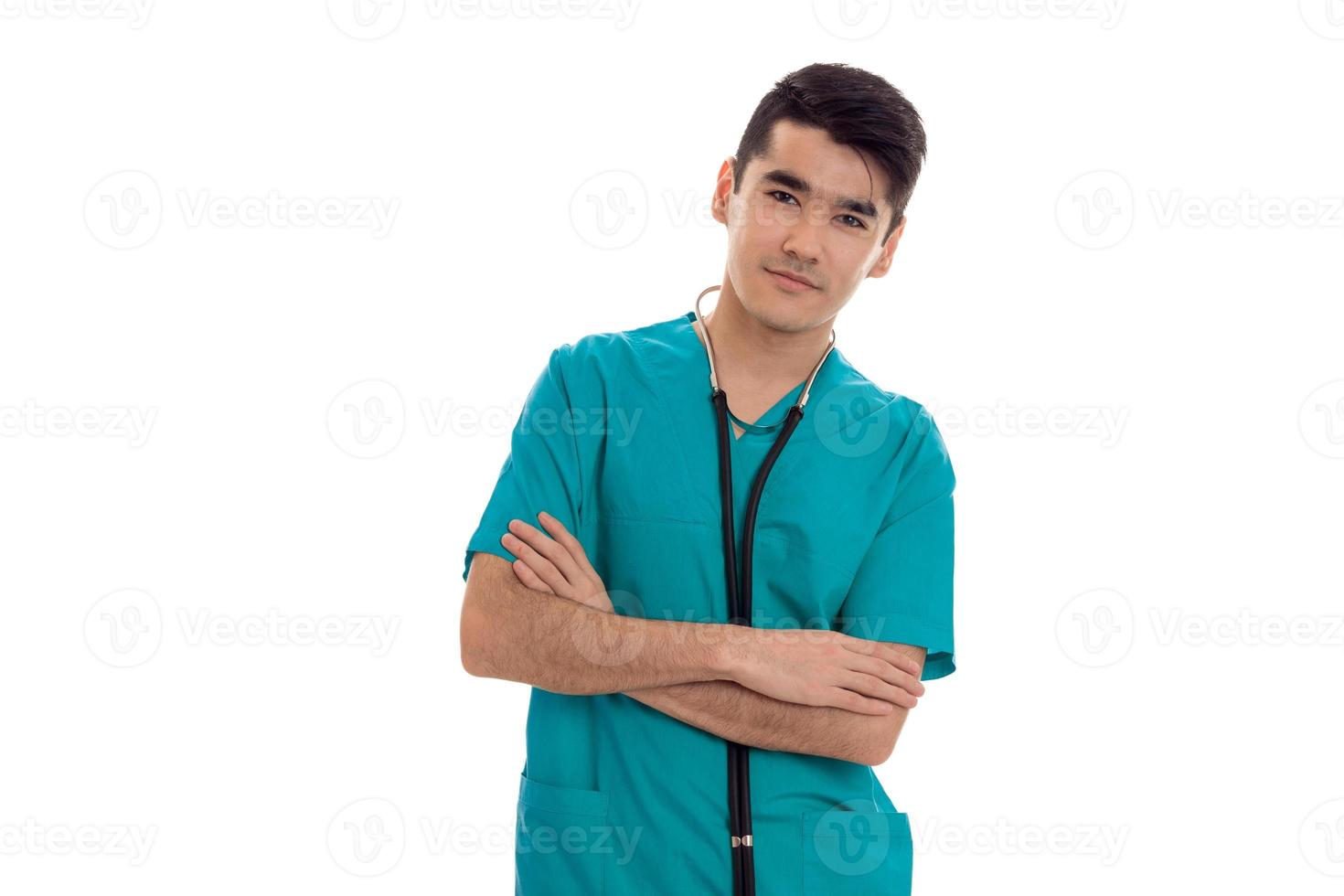 Jeune jolie brune médecin de sexe masculin en uniforme bleu avec stéthoscope sur son cou se présentant à la caméra isolé sur fond blanc photo