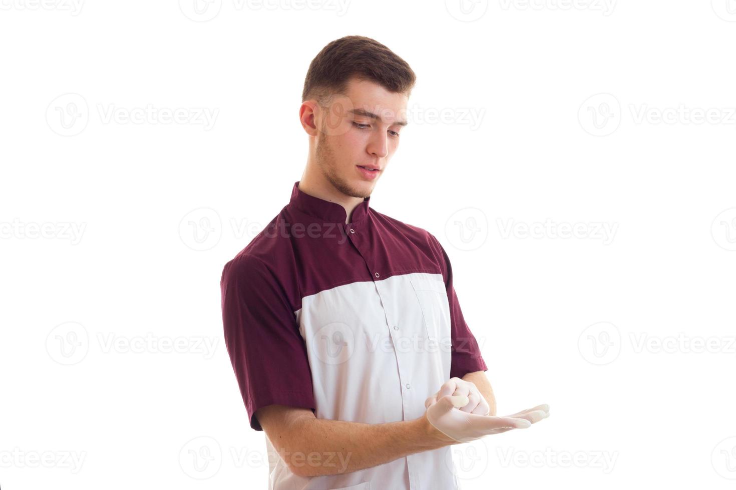 le jeune assistant médical porte des gants sur les mains photo