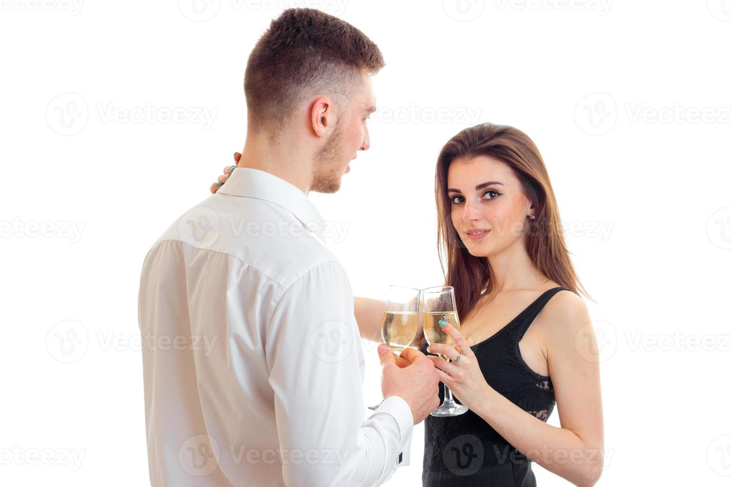 jolie jeune fille debout à côté d'un gars et tenant des verres à vin avec lui photo