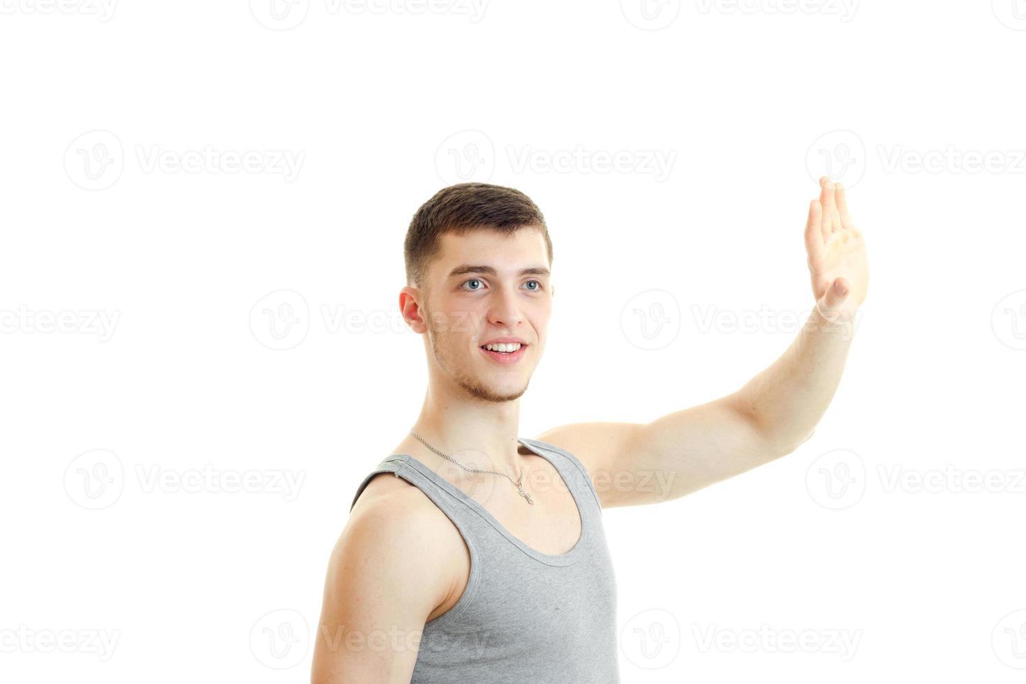 jeune homme charmant a levé la main et montre un geste photo