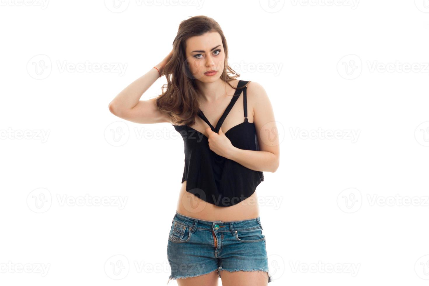 jeune brune sexy regarde la caméra et garde une main sur le corps de la chemise photo