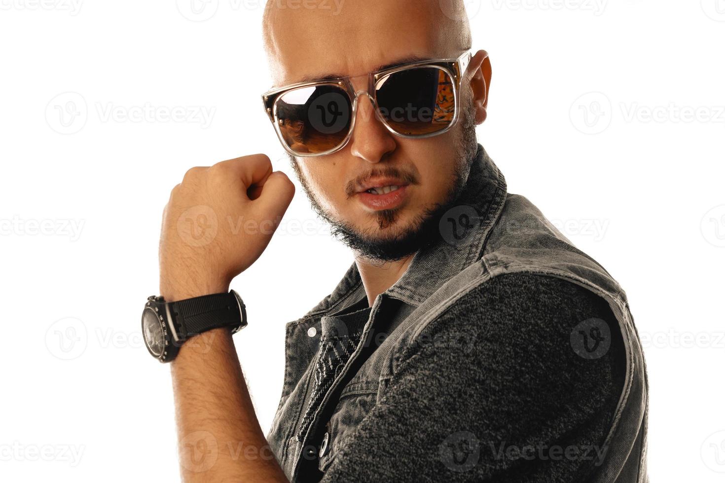 magnifique jeune macho à lunettes de soleil posant en studio photo