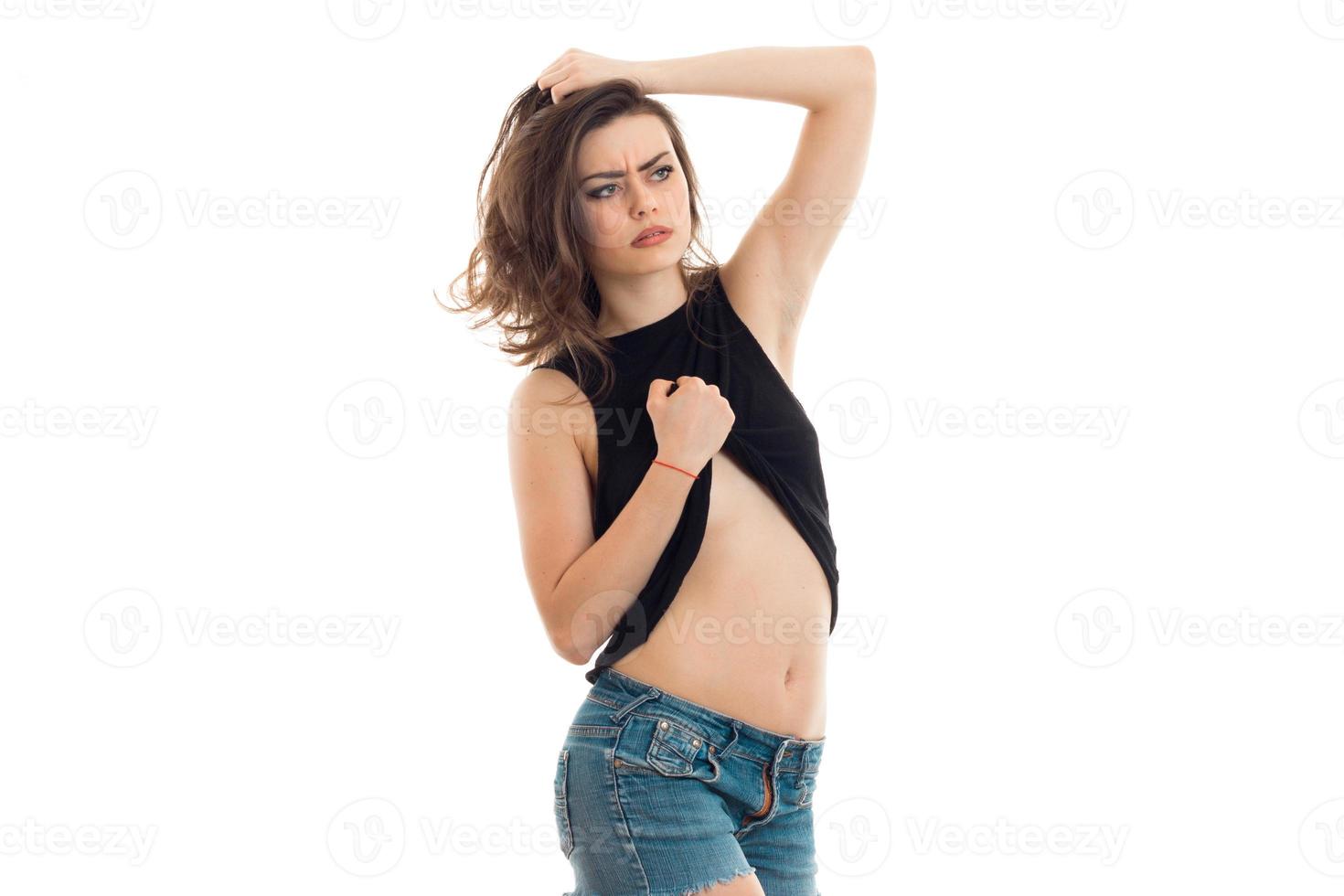 jeune magnifique brune érotique lève la main t-shirt et regardant la caméra photo