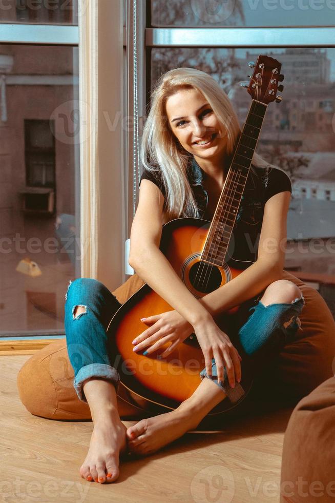 https://static.vecteezy.com/ti/photos-gratuite/p1/16518855-belle-jeune-fille-serrant-une-guitare-avec-les-mains-et-sourit-a-la-camera-photo.jpg