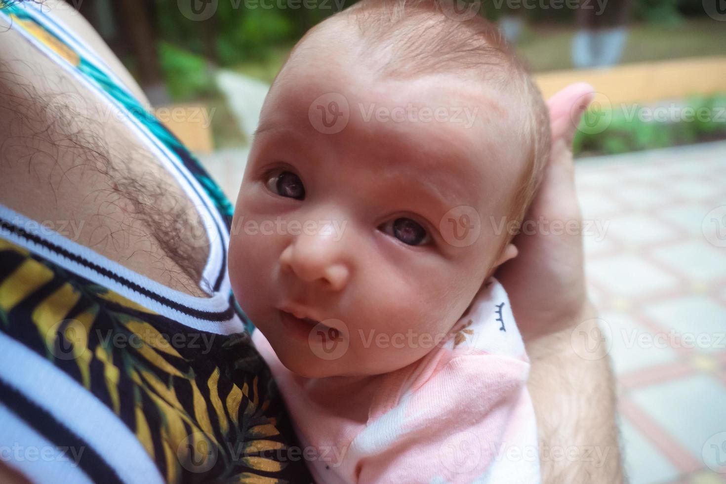 mignon petit bébé dans les bras de papa photo