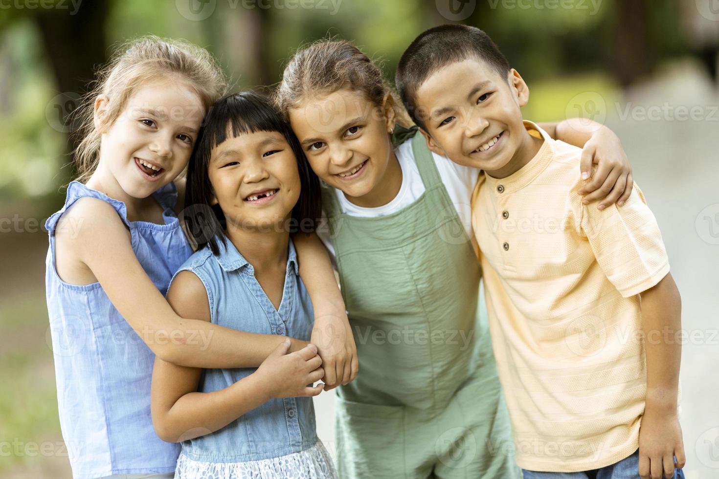 groupe d'enfants asiatiques et caucasiens s'amusant dans le parc photo