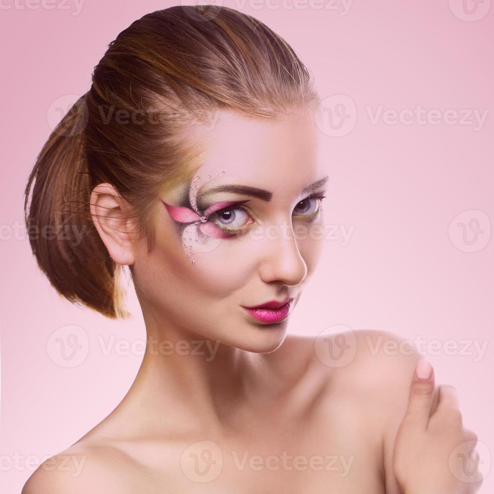 belle jeune fille avec maquillage regardant la caméra en studio photo