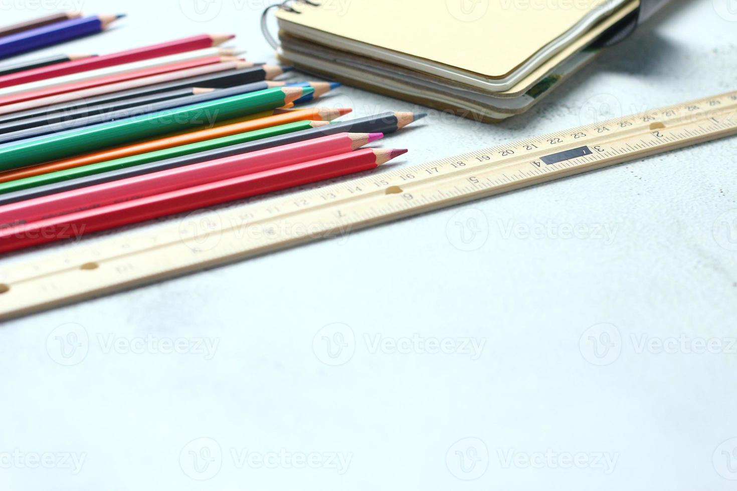 des crayons de bois éparpillés sur la table, des règles en bois et des cahiers avec le festival de retour au semestre, les élèves vont à l'école, des cours d'art. photo