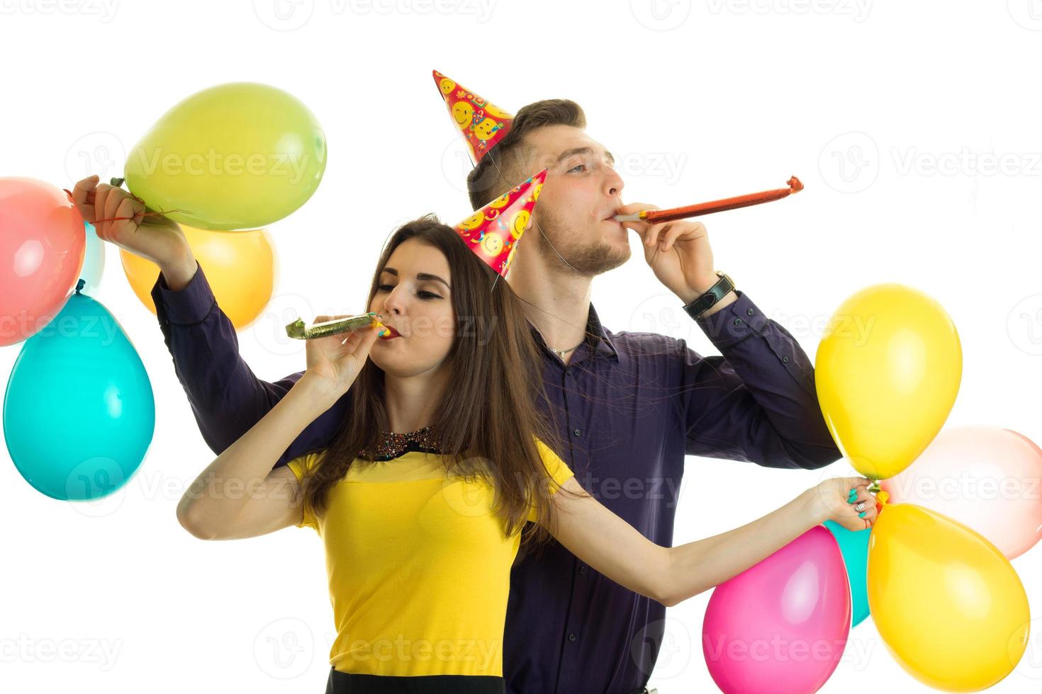 couple heureux à la fête d'anniversaire avec des cornes et des ballons photo