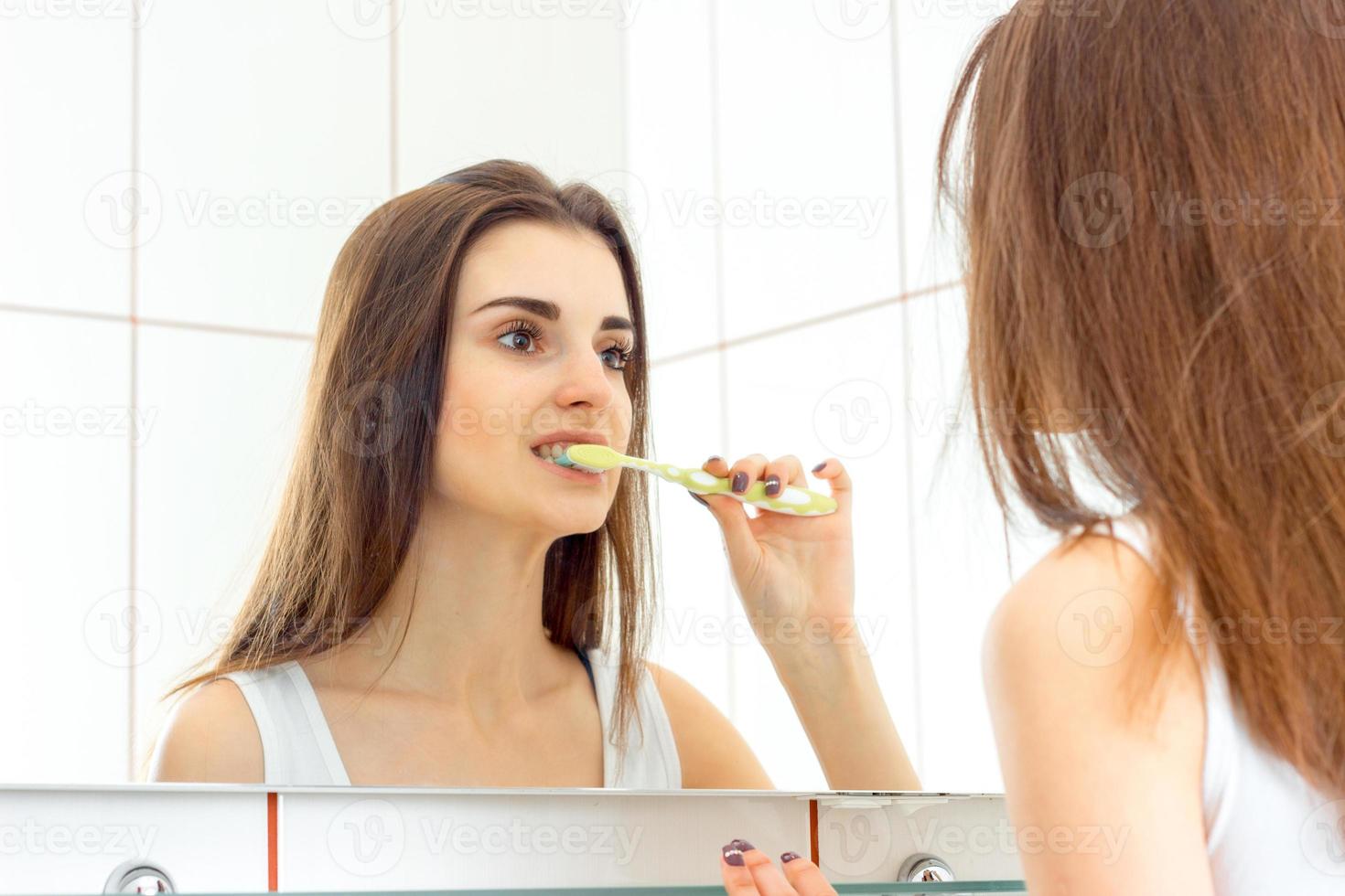 femme se brosser les dents avec une brosse avant le coucher photo