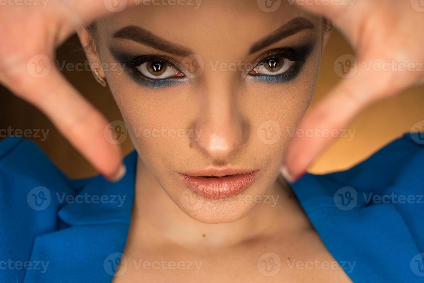 belle jeune fille en veste bleue avec maquillage de beauté en studio photo