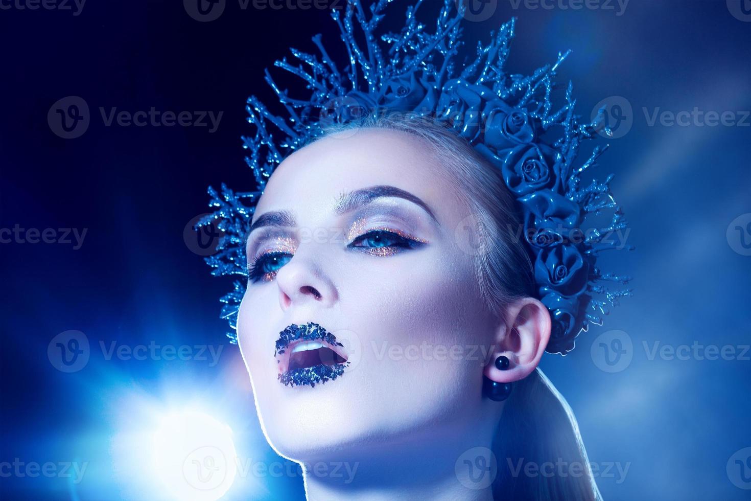 jeune femme adulte sensuelle sérieuse avec une couronne en studio photo