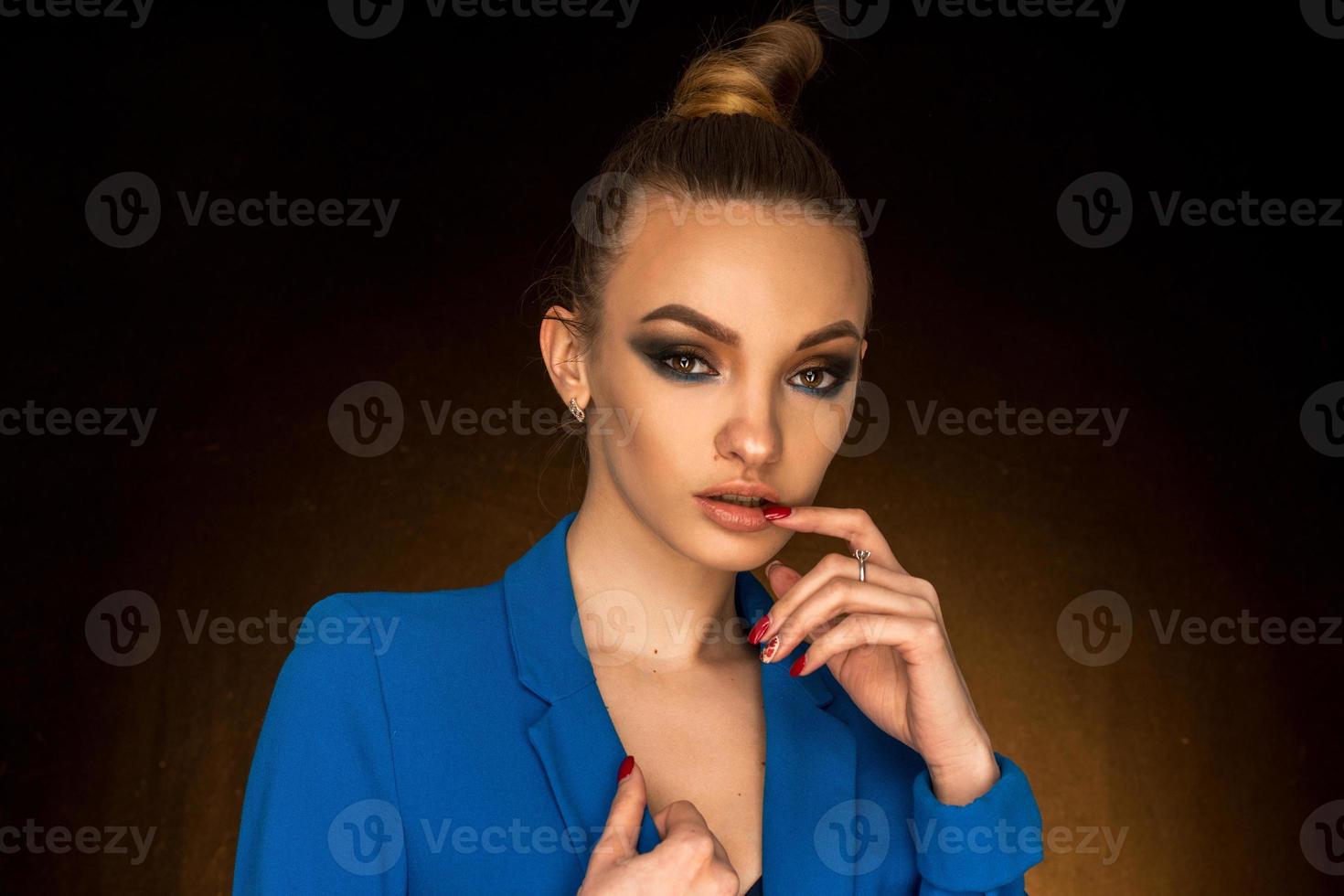 belle jeune fille en veste bleue avec maquillage de beauté en studio photo