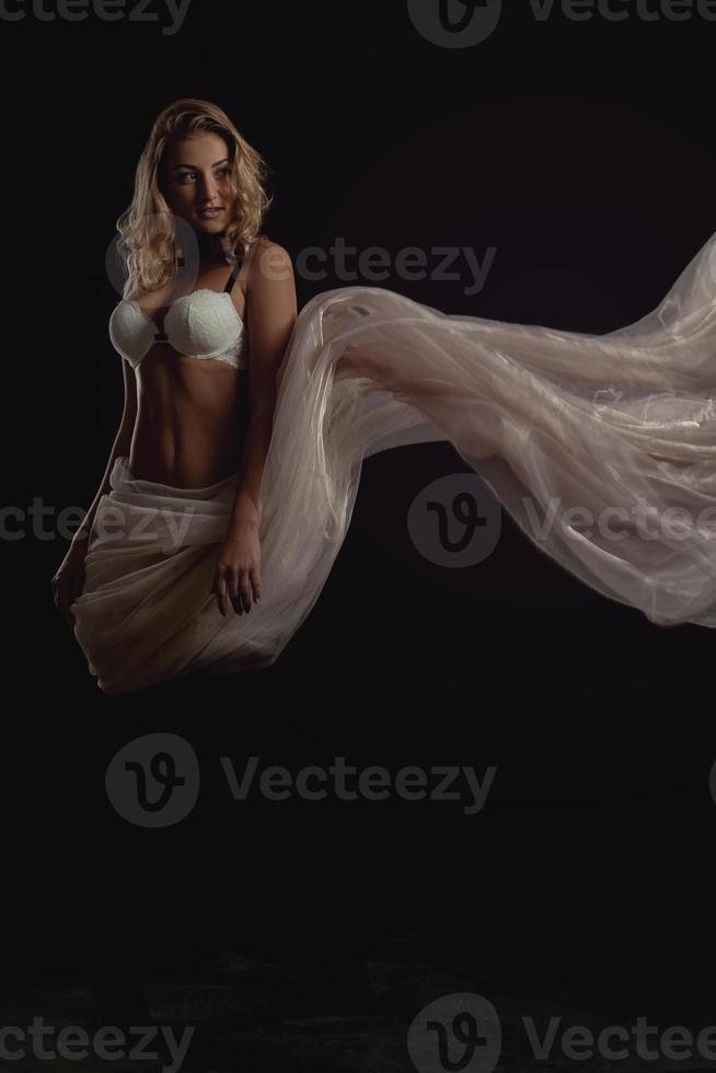Cutie jeune femme blonde en soutien-gorge blanc et tissu volant photo