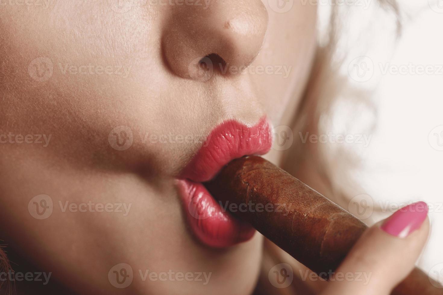 jeune fille avec un gros cigare brun dans les lèvres photo