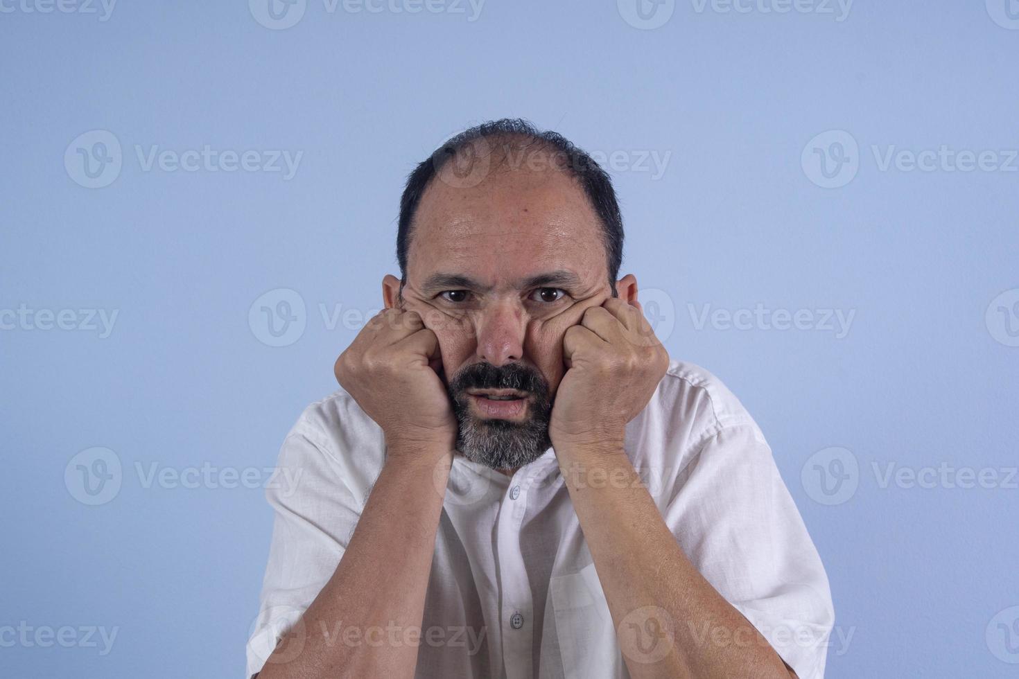 portrait d'homme barbu de 60 ans sur fond bleu photo