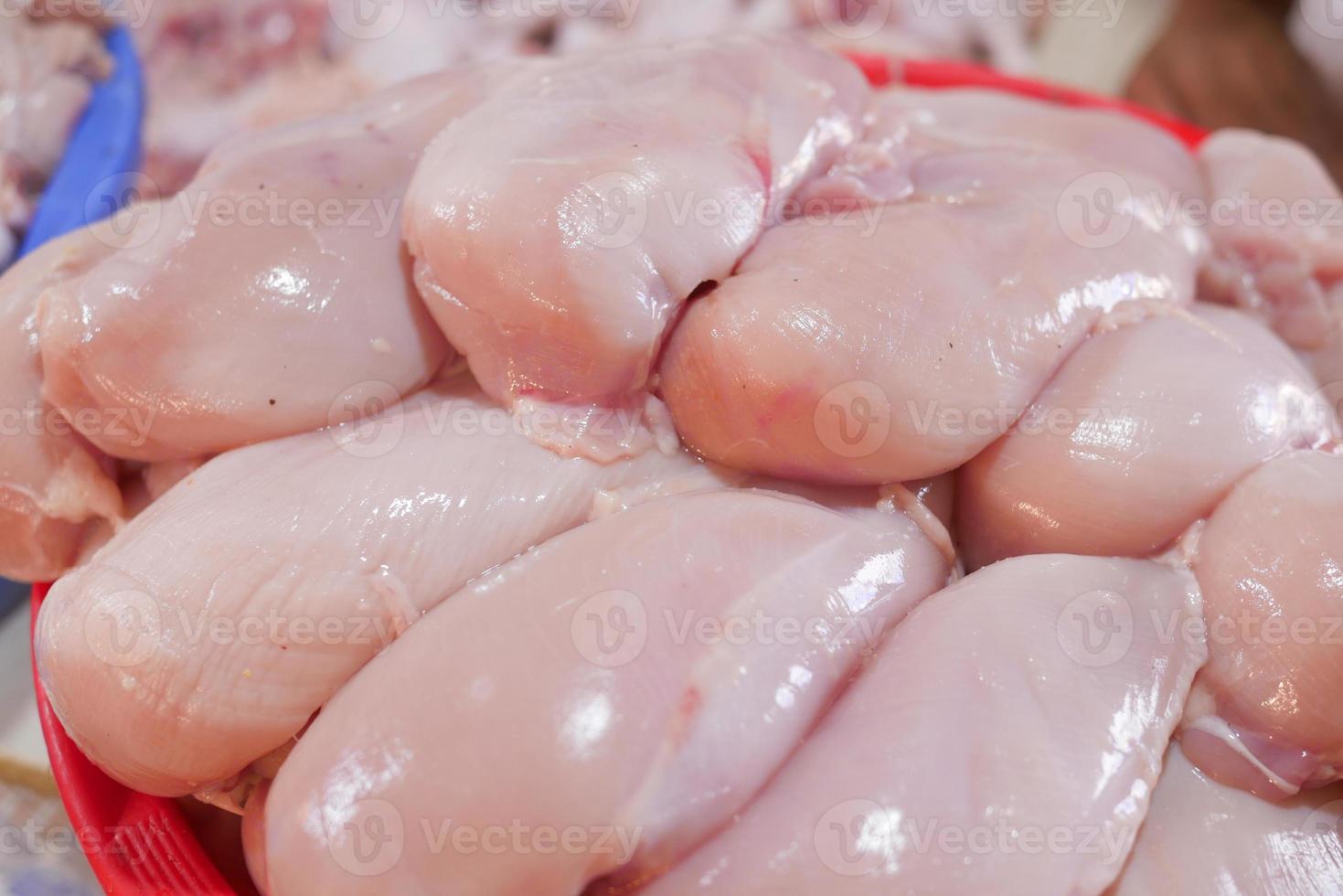 Viande crue de poitrine de poulet sur une assiette sur fond blanc photo