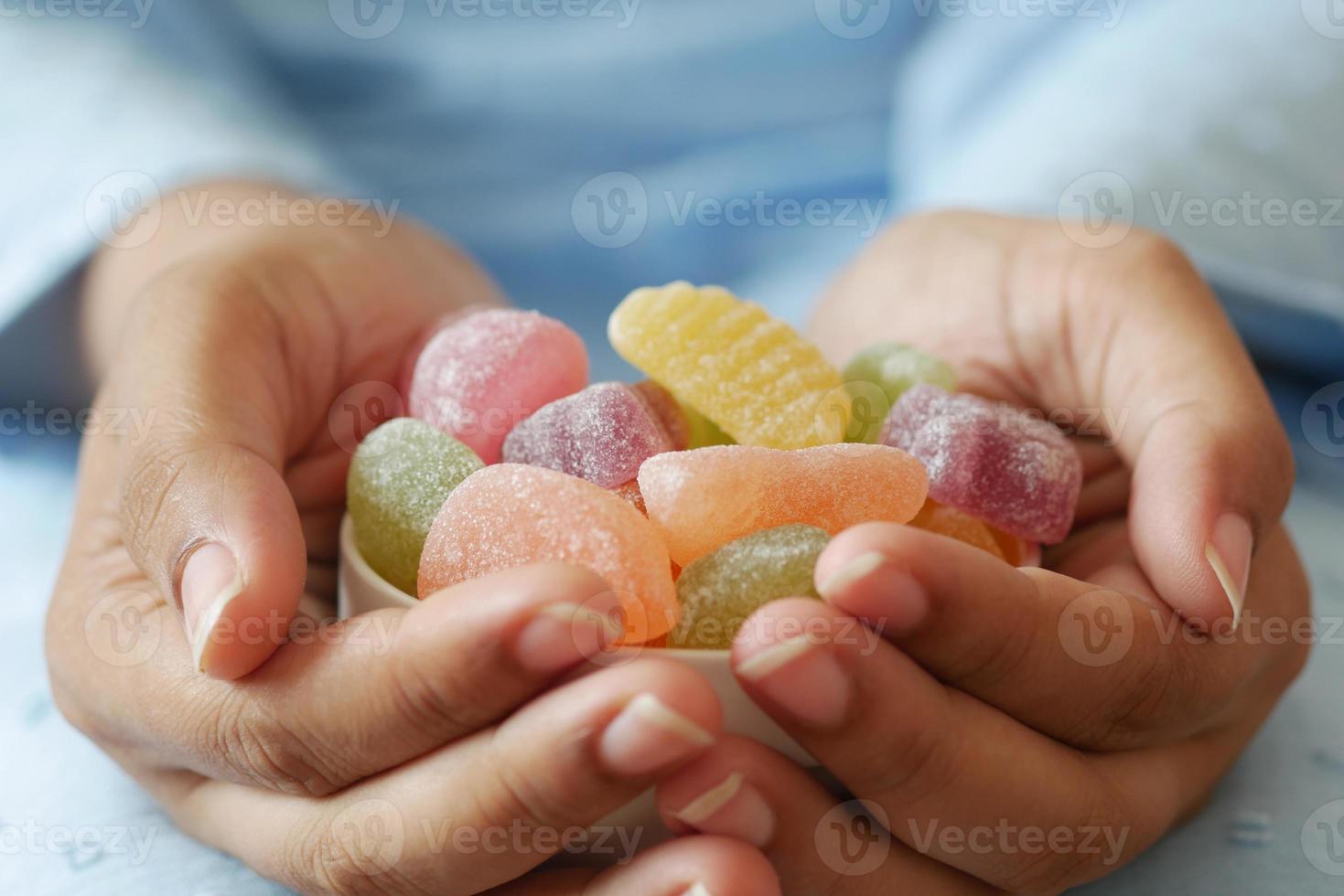femmes tenant un bol de bonbons gommeux colorés photo
