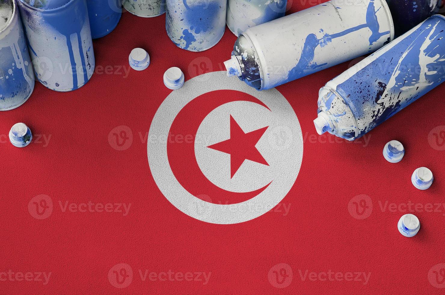 drapeau tunisien et quelques aérosols utilisés pour la peinture de graffitis. concept de culture d'art de rue photo