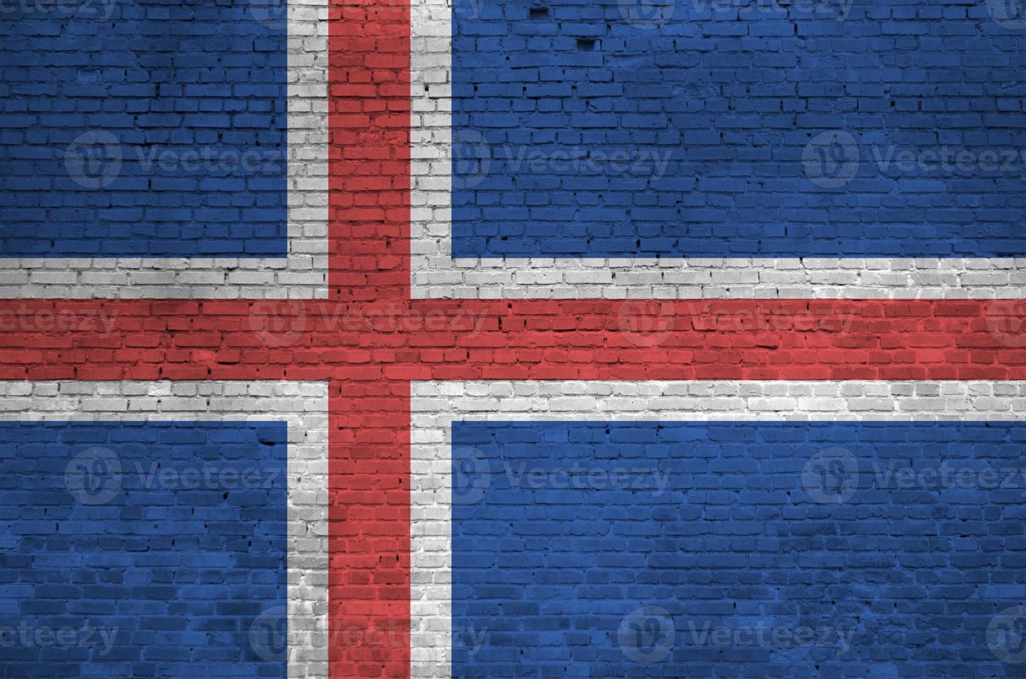 drapeau islandais représenté dans des couleurs de peinture sur un vieux mur de briques. bannière texturée sur fond de maçonnerie de gros mur de briques photo