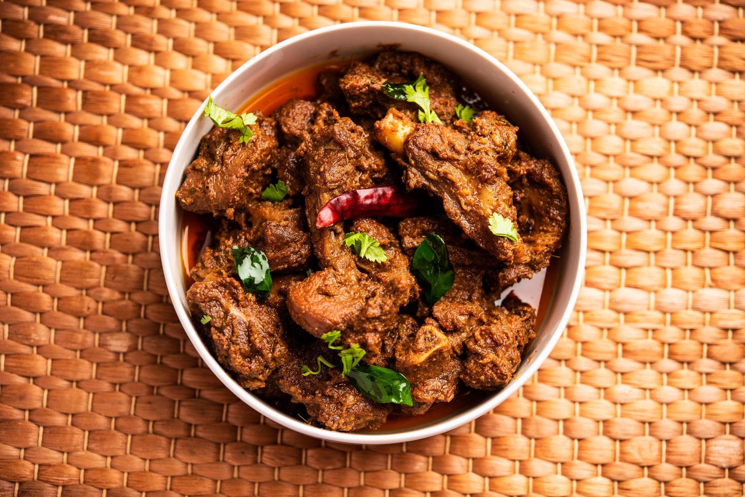 mouton ou poulet sukha, murgh épicé sec ou viande de chèvre servis dans une assiette ou un bol photo