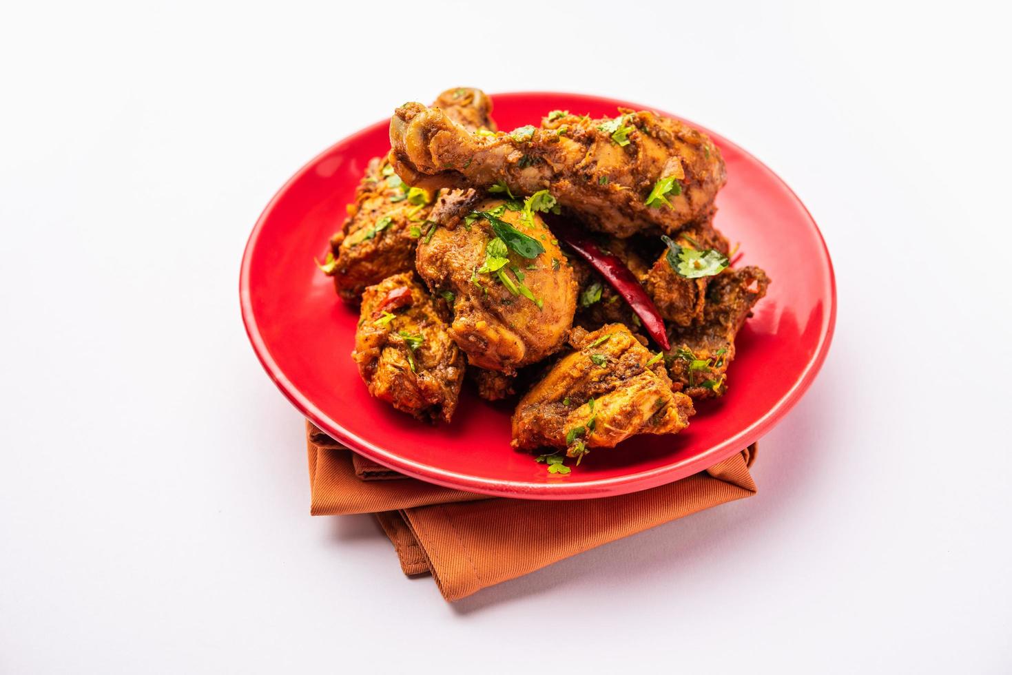 mouton ou poulet sukha, murgh épicé sec ou viande de chèvre servis dans une assiette ou un bol photo