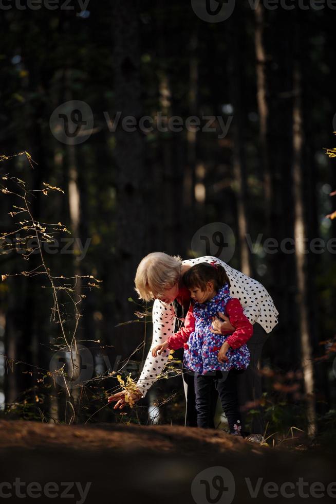 grand-mère et sa petite-fille autiste profitant de vacances ensemble à l'extérieur, allongées sur l'herbe verte sur une couverture et souriant à la caméra. loisirs vie familiale, bonheur et moments. photo