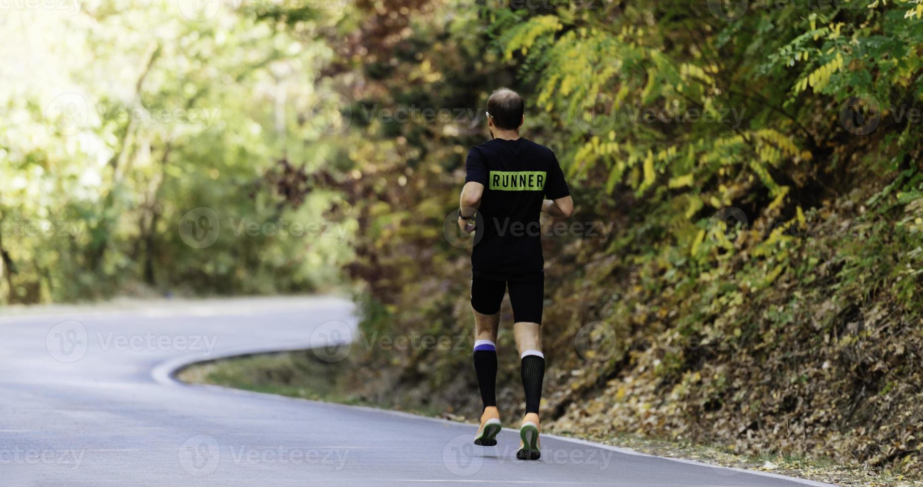 vue arrière d'un coureur sportif qui court sur un plateau de montagne en été photo