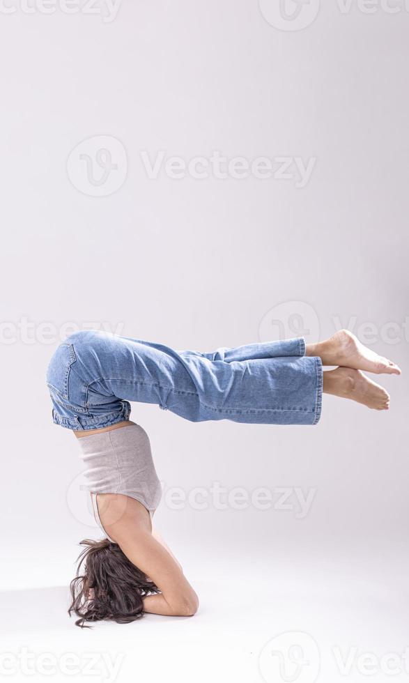 portrait d'une belle jeune femme avec un corps athlétique flexible faisant des étirements de jambe. isolée photo