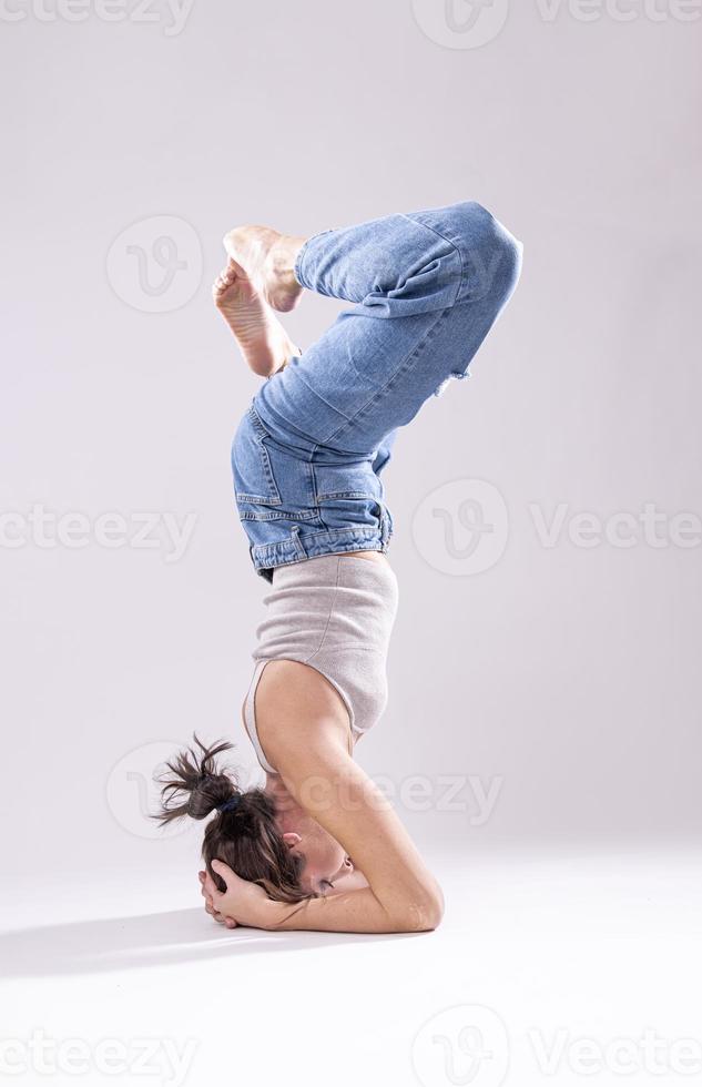 portrait d'une belle jeune femme avec un corps athlétique flexible faisant des étirements de jambe. isolée photo