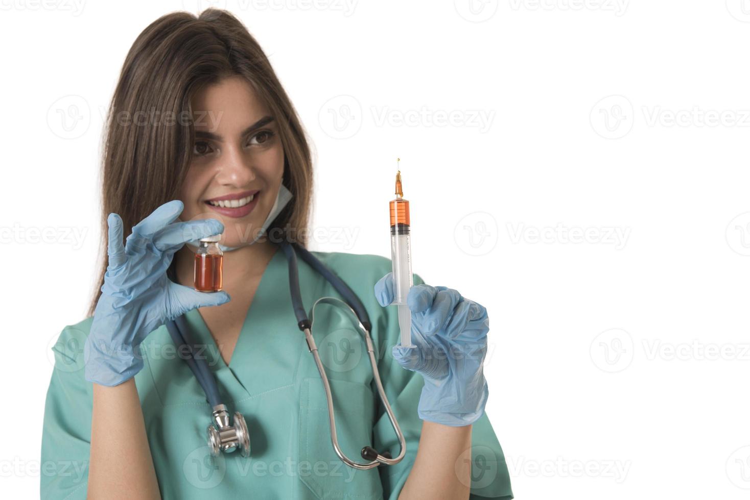 femme infirmière avec des vêtements de travail protecteurs tenant un vaccin et une seringue photo