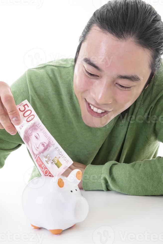 homme asiatique économiser de l'argent dans une tirelire photo