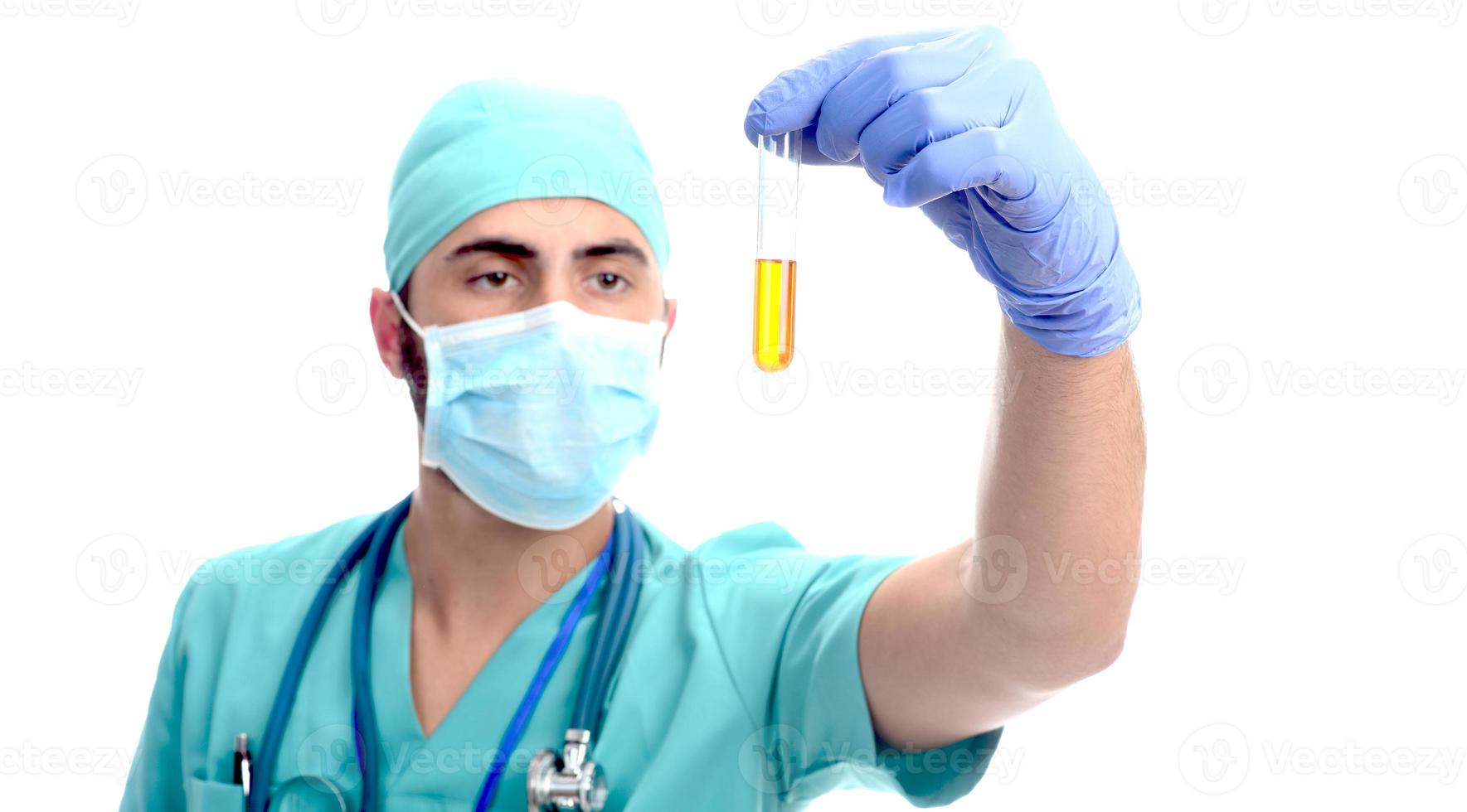 Chirurgien masculin avec masque tenant un échantillon d'urine isolé sur fond blanc photo