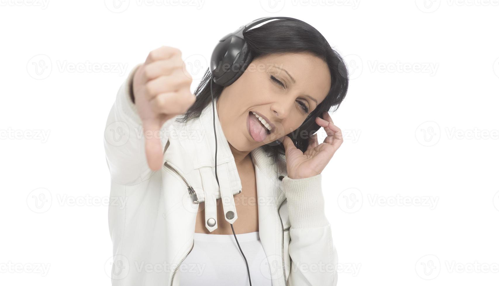 belle fille moderne chantant sa chanson préférée, écoutant de la musique dans des écouteurs sans fil, souriant et dansant photo