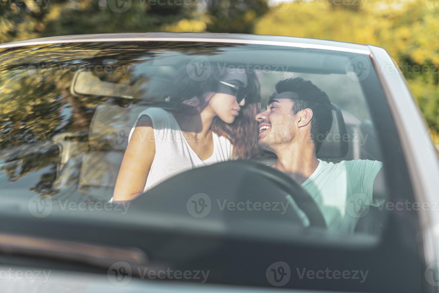 amis s'amusant lors d'un voyage en voiture autour du monde. couple amoureux avec les bras levés sur une voiture décapotable. photo