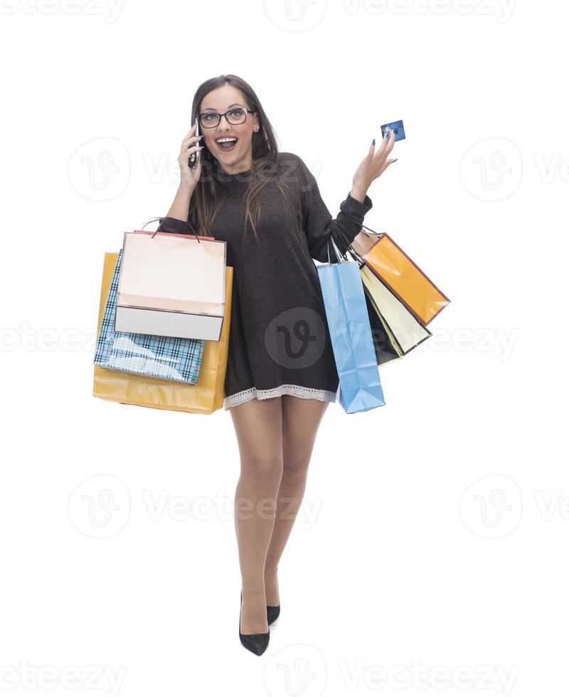 femme heureuse avec sac à provisions sur fond de studio isolé. photo