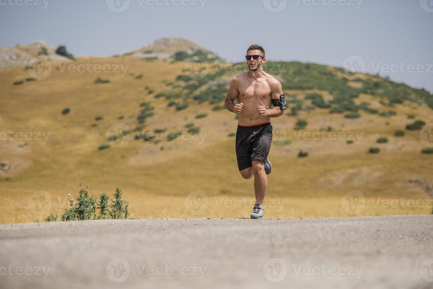 coureur d'homme sportif courant sur le plateau de montagne en été photo