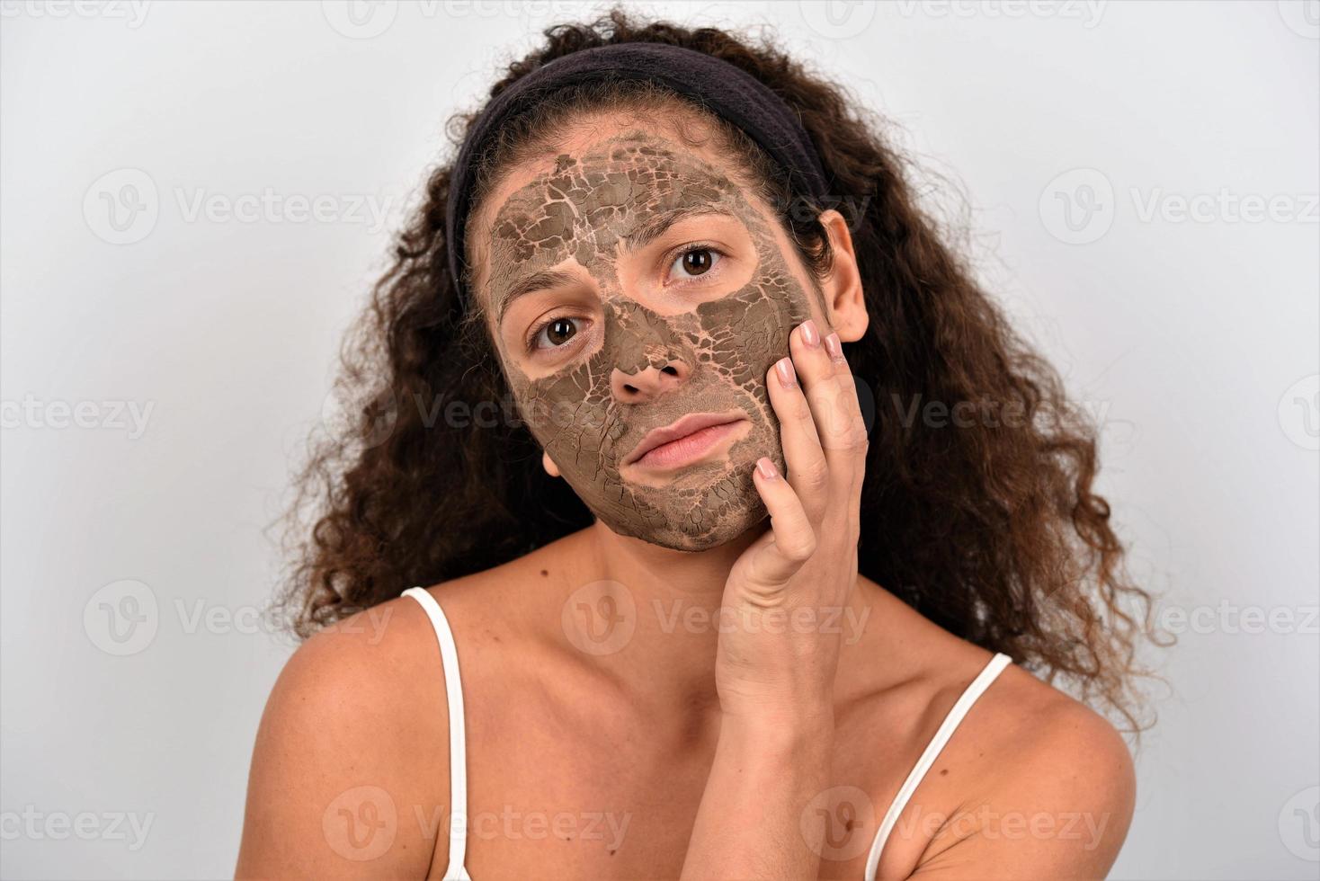 belle femme ayant un soin du visage à l'argile photo