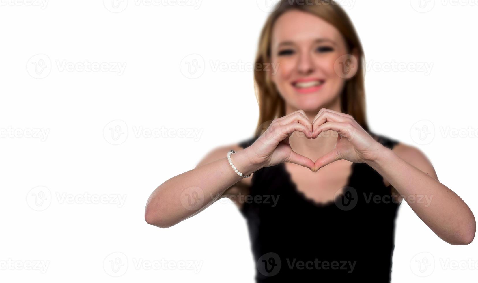 portrait d'une jeune femme faisant un geste de coeur avec ses mains photo