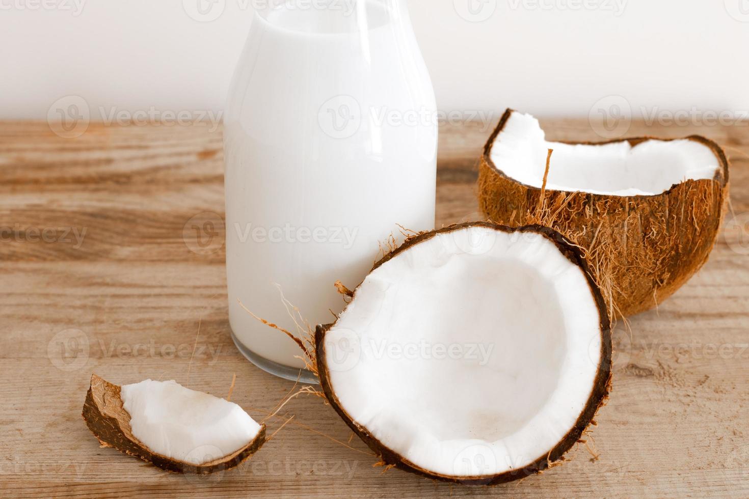 lait de coco frais dans une bouteille en verre, boisson saine végétalienne non laitière. table en bois, gros plan. photo